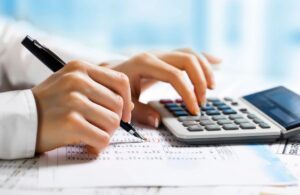 Person using a calculator to calculate taxes