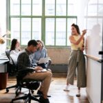 Businesspeople taking notes and writing on a white board