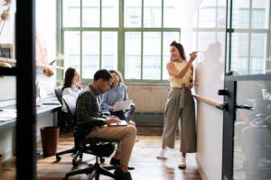 Businesspeople taking notes and writing on a white board