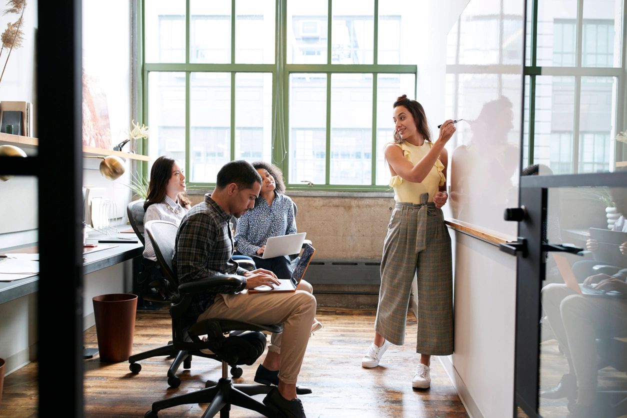 Businesspeople taking notes and writing on a white board