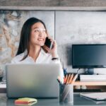 Businesswomen on the phone sitting at her desk.