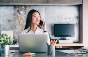 Businesswomen on the phone sitting at her desk.