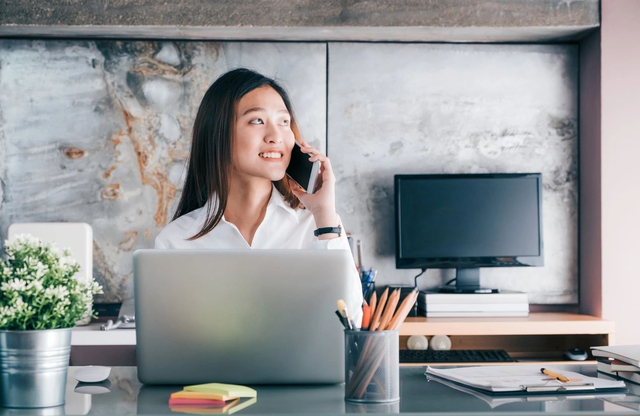 Businesswomen on the phone sitting at her desk.